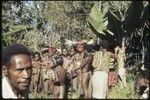 Bride price for Aina: payment, observed by group of children and young women, some wearing elaborate headdresses, shell pendants, and other ornaments