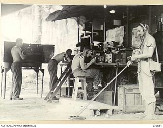 ALEXISHAFEN, NEW GUINEA. 1944-09-13. WIRELESS SECTION PERSONNEL OF THE 133RD BRIGADE WORKSHOPS REPAIRING AND TESTING MINE DETECTING EQUIPMENT. IDENTIFIED PERSONNEL ARE:- NX157125 CRAFTSMAN J.F. ..