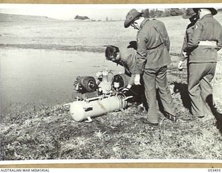 ASCOT RACECOURSE, SYDNEY, NSW. 1943-07-12. PERSONNEL OF THE HYGIENE SECTION OF THE NEW SOUTH WALES LINES OF COMMUNICATION AREA TESTS AN OUTFIT FOR SPRAYING SWAMPS AND PONDS IN NEW GUINEA, AND OTHER ..