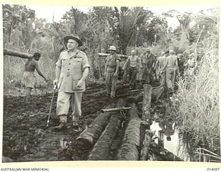 1943-01-14. ROAD BUILDERS FOLLOWING UP THE ADVANCING ALLIED TROOPS. TANKS SLITHERED ALONG THIS PATH IN THE FIGHT AGAINST THE JAPS AND INFANTRY, CARRYING HEAVY EQUIPMENT, OFTEN SANK TO THEIR KNEES ..