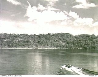 NEW BRITAIN, 1945-09. LANDING CRAFT FERRYING MEMBERS OF THE AUSTRALIAN MISSING PRISONERS INVESTIGATION UNIT (MPIU) FROM SHIP TO SHORE IN SIMPSON HARBOUR, RABAUL. (RNZAF OFFICIAL PHOTOGRAPH.)