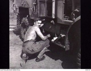 BISIATABA, NEW GUINEA. 1943-11-04. VX85063 DRIVER J. A. LAWTON OF HEADQUARTERS, NEW GUINEA FORCE DOING SOME ROADSIDE REPAIRS ON HIS TRUCK