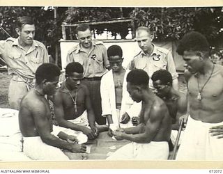 HELDSBACH PLANTATION, NEW GUINEA. 1944-04-06. CONVALESCENT MEMBERS OF THE PAPUAN INFANTRY BATTALION PLAYING CARDS AT THE 106TH CASUALTY CLEARING STATION WITH SOME OF THEIR ORDERLIES VIEWING THE ..