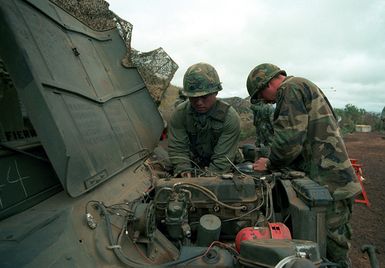 STAFF Sergeant Joseph M. Benavente and Private Joseph M. Lake of the 25th Infantry Division, perform maintenance on a jeep during annual training exercises