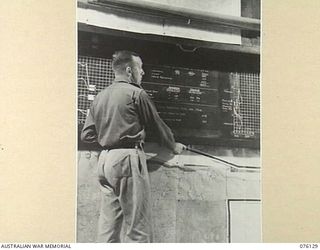LAE, NEW GUINEA. 1944-09-12. SERGEANT C.H. TYTE, AT WORK IN THE BATTLE ROOM, HEADQUARTERS NEW GUINEA FORCE