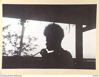 SIPILANGAN, NEW BRITAIN, 1945-07-30. A SILHOUETTE STUDY OF A HOUSE GIRL AT THE AUSTRALIAN NEW GUINEA ADMINISTRATIVE UNIT DISTRICT SERVICES TOL REFUGEE CAMP. THE CAMP, SITUATED AT WIDE BAY, HOUSES ..