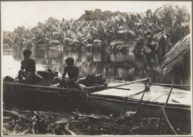 Nipa Palms, Opi River, [two men in a boat on the river edge with palm trees in the background] Frank Hurley