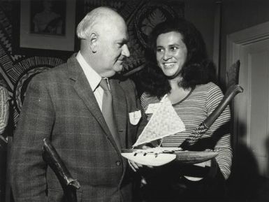 Former Fijian Akesa Jo of Levuka, handing a man artifacts, approximately 1972