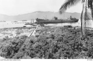 MILNE BAY, PAPUA, NEW GUINEA. 1944-04-03. A GENERAL VIEW OF THE OIL WHARF WITH 'EMPIRE SILVER', AN OIL TANKER DISCHARGING CARGO AND SMALLER VESSELS REFILLING FUEL TANKS. THE FUEL IS PIPED DIRECTLY ..