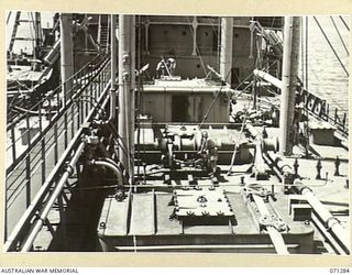 PORT MORESBY, PAPUA, 1944-03-21. THE OIL TANKS AND PUMPING PLANT ON THE AFT SECTION OF THE OIL TANKER EMPIRE SILVER. THE PERSON HOLDING THE DIP TAPE, USED IN CHECKING THE QUANTITY OF OIL ABOARD, IS ..