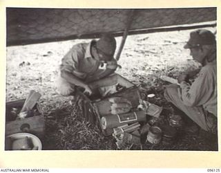 MUSCHU ISLAND, NEW GUINEA. 1945-09-11. A JAPANESE DOCTOR INSPECTING MEDICAL STORES WHICH WERE BROUGHT TO THE ISLAND BY ASSISTANT DIRECTOR OF MEDICAL SERVICES PERSONNEL FROM HEADQUARTERS 6 DIVISION ..