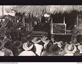 KAIAPIT, NEW GUINEA. 1943-09-26. NX4082 MAJOR D. R. OWEN, BRIGADE MAJOR, HEADQUARTERS 21ST AUSTRALIAN INFANTRY BRIGADE, WITH THE AID OF A BLACKBOARD LECTURING THE TROOPS ON THE PROGRESS OF THE ..