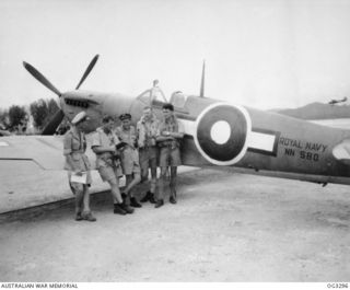 LORENGAU, MANUS ISLAND, ADMIRALTY ISLANDS. 1945-08-25. TWO YOUNG RAAF AIRMEN WITH MEMBERS OF THE ROYAL NAVY SEAFIRE SQUADRON ON A HITHERTO SECRET BASE, MANUS ISLAND. SHOWN: 413861 FLYING OFFICER R. ..