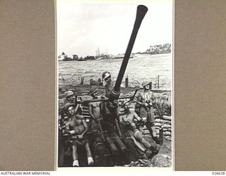 MILNE BAY, PAPUA. 1942-09. A BOFORS 40 MM ANTI-AIRCRAFT GUN CREW AT ACTION STATIONS NEAR THE WHARF AT GILI GILI. THE WHARF IS IN THE BACKGROUND AND ALSO THE STEAMER ANSHUN THAT THE JAPANESE SHELLED ..