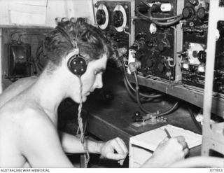 AT SEA 1944-12-30 - 1945-01-01. TELEGRAPHIST C.D. MANN, RADIO OPERATOR, ABOARD THE RAN VESSEL, ML802 RECEIVING AN URGENT MESSAGE FROM THE RAN PORT DIRECTORATE AT JACQUINOT BAY TO PROCEED TO CUTARP ..