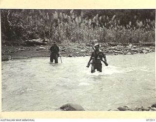 YAULA, NEW GUINEA. 1944-04-12. MEMBERS OF THE MILITARY HISTORY SECTION CROSSING THE MINDJIM RIVER BELOW DAMOINA DURING THE ADVANCE OF THE 57/60TH INFANTRY BATTALION TO BOGADJIM. IDENTIFIED ..