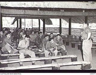 RABAUL, NEW BRITAIN, 1945-12-19. MEMBERS OF 26TH INFANTRY BATTALION LISTENING TO A LECTURE ON POPULATION PROBLEMS CONDUCTED BY AN OFFICER OF AUSTRALIAN ARMY EDUCATION SERVICES