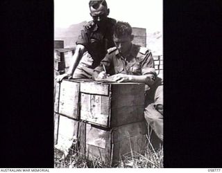 RAMU VALLEY, NEW GUINEA. 1943-10-07. NX26614 LIEUTENANT W. HOLLOMAN (LEFT) AND VX51658 CAPTAIN S. CHAPPLE, OFFICER COMMANDING, NO. 5 PLATOON, 2/2ND AUSTRALIAN SUPPLY DEPOT COMPANY, AUSTRALIAN ARMY ..