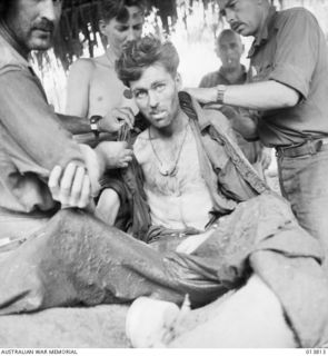 1942-12-11. PAPUA GONA. AN AUSTRALIAN OFFICER, WHO HAS JUST CRAWLED IN AFTER LYING EIGHT DAYS WOUNDED NEAR JAPANESE LINES, RECEIVED TREATMENT. HE WAS ONLY A FEW FEET AWAY FROM JAPANESE DUG-OUTS AND ..