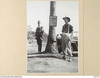 RABAUL, NEW BRITAIN. 1945-10-06. CORPORAL W.J. VOSILLA, 11 DIVISION PROVOST COMPANY, ON DUTY WITH A JAPANESE MILITARY POLICEMAN AT HEADQUARTERS 11 DIVISION CAR PARK