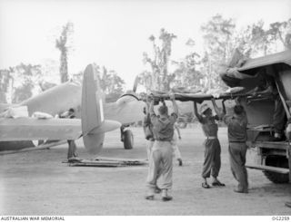 TOROKINA, BOUGAINVILLE ISLAND, SOLOMON ISLANDS. C. 1945-02-18. ARMY PATIENT BEING LIFTED FROM AMBULANCE PRIOR TO BEING LOADED ON AN AIR AMBULANCE AIRCRAFT OF NO. 37 (TRANSPORT) SQUADRON RAAF AT ..