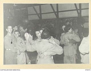 LAE, NEW GUINEA. 1944-10-03. V301142 PRIVATE W.R. BARRY (1) AND V155268 PRIVATE C.H. WILSON (2) OF THE 22ND WORKS COMPANY OVERCOME THE SCARCITY OF GIRLS AT THE DANCE HELD IN THE NEW UNIT RECREATION ..