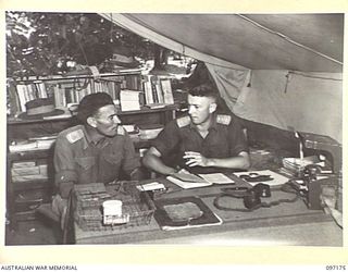 MALAGUNA, RABAUL, NEW BRITAIN. 1945-09-25. CAPTAIN F.C. JACOBS, OFFICER COMMANDING 13 BRIGADE SIGNAL SECTION (2), CONFERRING WITH MAJOR G.K. ANDERSON, OFFICER COMMANDING 2 COMPANY, 11 DIVISION ..