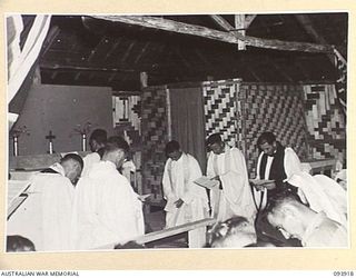 TOROKINA, BOUGAINVILLE, 1945-07-12. CHAPLAIN GENERAL C.L. RILEY, CHURCH OF ENGLAND, OFFICIATING AT THE CONFIRMATION SERVICE IN THE NEW CHAPEL AT HEADQUARTERS 2 CORPS. FIFTY-THREE MEMBERS WERE ..