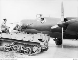 NEW GUINEA, 1942-08-11. PERSONNEL OF THE 39TH INFANTRY BATTALION, AUSTRALIAN MILITARY FORCES, IN THEIR BREN GUN CARRIER PAY A VISIT TO THE CREW OF AN AMERICAN B-26 BOMBER AS IT STANDS BY ON A NEW ..