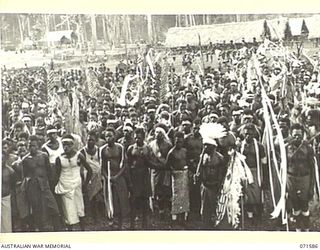 SONG RIVER, FINSCHHAFEN AREA, NEW GUINEA. 1944-03-26. NATIVES LISTENING TO AN ADDRESS GIVEN BY THE OFFICER COMMANDING FINSCHHAFEN BASE SUB-AREA DURING A LULL IN FESTIVITIES HELD AT THE AUSTRALIAN ..