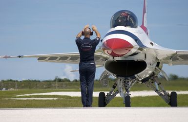 U.S. Air Force TECH. SGT. Brian Plauche, a Crew CHIEF assigned to the U.S. Air Force Thunderbirds Aerial Demonstration Team, marshals the F-16C Fighting Falcon aircraft"Thunderbird 8"into position, after the Team Landed at Andersen Air Force Base, Guam, September 9, 2004. This landing marks the first time in a decade the USAF Thunderbird demonstration team has visited Guam. The Thunderbirds will be performing during an air show held Sunday, September 12, 2004. (U.S. Air Force PHOTO by STAFF SGT. Bennie J. Davis III) (Released)