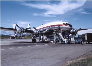 Ground crew prepare Qantas Lockheed L-1049 Super Constellation jetliner VH-EAI, Southern Sun, at Nadi Airport, Fiji, ca. 1955 / Russell Smith