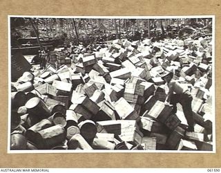 FINSCHHAFEN, NEW GUINEA. 1943-11-20. GENERAL VIEW OF THE AUSTRALIAN ARMY SUPPLY DUMP, SHOWING NX51358 CORPORAL J. DAY AT WORK SORTING CASES OF SUPPLIES