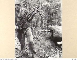 TOROKINA AREA, BOUGAINVILLE ISLAND. 1944-11-29. QX57463 CORPORAL H.L. MORRIS, NO.18 PLATOON D COMPANY, 9TH INFANTRY BATTALION, INSPECTING A JAPANESE LIGHT MACHINE GUN CAPTURED DURING THE ATTACK ON ..