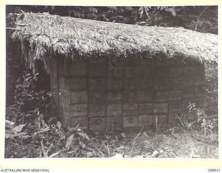 RABAUL, NEW BRITAIN. 1945-11-20. A GOOD EXAMPLE OF A CAMOUFLAGED FIELD STACK OF JAPANESE AMMUNITION IN STORAGE IN 11 DIVISION AREA