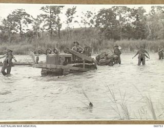 RAMU VALLEY, NEW GUINEA. 1943-11-26. A LIGHT 25 POUNDER GUN OF NO. 8 BATTERY, 2/4TH. AUSTRALIAN FIELD REGIMENT BEING HAULED ACROSS THE EVAPIA RIVER IN THE KESAWAI AREA. SHOWN ARE: VX50239 LANCE ..