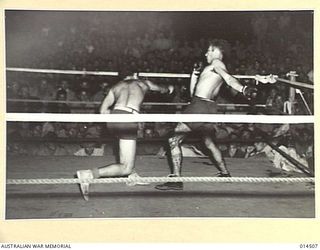 1943-03-29. NEW GUINEA. CAUSE AND EFFECT SOMEWHERE IN NEW GUINEA. A RIGHT WHICH MISSED AT AN RAAF BOXING TOURNAMENT CAUSED VARIOUS EXPRESSIONS ON ONLOOKERS FACES. (NEGATIVE BY N. BROWN)