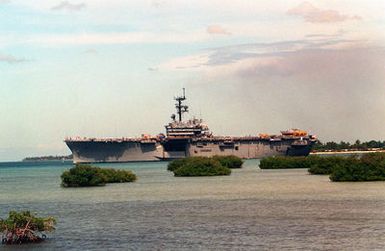 The amphibious assault ship USS TRIPOLI (LPH-10) heads toward the mouth of the channel as it departs from the naval station after a visit. The TRIPOLI is en route to its home port of Naval Station, San Diego, Calif., after serving in the Persian Gulf region during Operation Desert Shield and Operation Desert Storm.