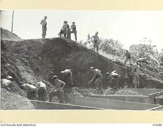 NAGADA, NEW GUINEA. 1944-07-09. TROOPS OF THE 15TH FIELD COMPANY, DIGGING EARTH FILLING FROM ONE OF THE UNIT QUARRIES DURING THE REBUILDING OF THE MADANG-ALEXISHAFEN ROAD. IDENTIFIED PERSONNEL ..