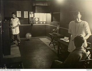 Port Moresby, New Guinea. 1944-05-29. Lieutenant R.B. Stevens testing a patient's eyesight at the Opthalmic Department of the 128th Australian General Hospital (128AGH). Private R.F. Welladsen is ..