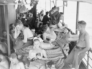 AT SEA. 1945-03-30. 2/48 INFANTRY BATTALION TROOPS ENJOYING A PEACEFUL MORNING ABOARD THE VAN HEUTSZ DURING THE EMBARKATION OF HEADQUARTERS 26 INFANTRY BRIGADE TO MILNE BAY