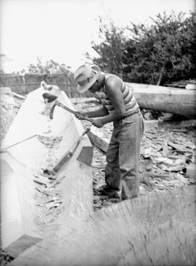 Man hollowing out the shell of a waka