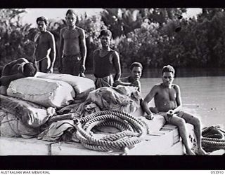 TERAPO, NEW GUINEA. 1943-06-30. NATIVE LABOURERS ON THEIR LAKETOI CRAFT BEING TOWED TO BULLDOG BY A BARGE OF THE 1ST AUSTRALIAN WATER TRANSPORT GROUP (SMALL CRAFT)