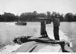 SORAKEN AREA, BOUGAINVILLE, 1945-05-06. A MEMBER OF 26 INFANTRY BATTALION (A.I.F.) MANNING A VICKERS MACHINE-GUN ON A LANDING BARGE DURING A TRIAL LANDING ON THE BEACH AT TOROKORI ISLAND