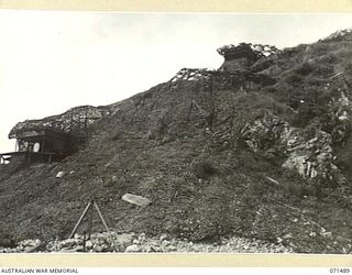 PORT MORESBY, PAPUA, NEW GUINEA. 1944-03-27. THE CAMOUFLAGED COMMAND POST AT PAGA BATTERY, COAST ARTILLERY VIEWED FROM THE BEACH. THE BATTERY, EQUIPPED WITH AN ANTI-AIRCRAFT SEARCHLIGHT AND TWO 6 ..