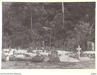 FAURO ISLAND, BOUGAINVILLE AREA. 1945-11-12. JAPANESE WORKING PARTY CLEARING A NATIVE CEMETERY. THE OVERGROWTH HAS BEEN CLEARED AND CLEAN SAND PLASTERED ON THE TOP OF GRAVES. JAPANESE ARMY AND ..