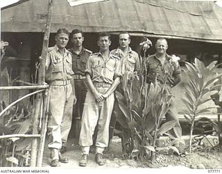 LAWE BASE AREA, NEW GUINEA. 1944-12-29. THE OFFICER- IN- CHARGE AND THE ORDERLY ROOM STAFF OUTSIDE THE UNIT ORDERLY ROOM. IDENTIFIED PERSONNEL ARE:- N198824 SIGNALLER W. BLAIN (1); NX102353 ..