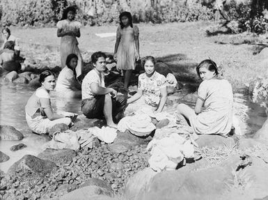 [Pacific Island women sitting by river]