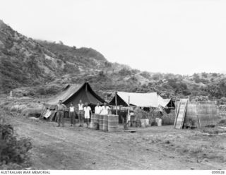 RABAUL, NEW BRITAIN, 1946-03-16. OF THE 653 CHINESE WHO DIED WHILST CAPTIVES OF THE JAPANESE, 259 WERE RE-INTERRED IN A CHINESE CEMETERY AT RABAUL. SHOWN, THE CARETAKER;S TENT AND MEMBERS OF THE ..