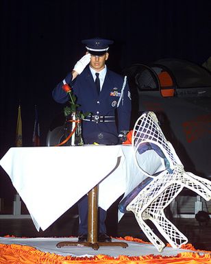 Hickam honor guard member pays tribute to the POW/MIA table during the Korean Symposium reception held at Hickam AFB, Hawaii
